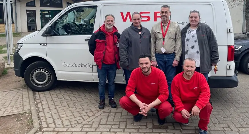 Sechs WSR-Mitarbeitende in roter Arbeitskleidung vor einem weißen WSR-Transporter